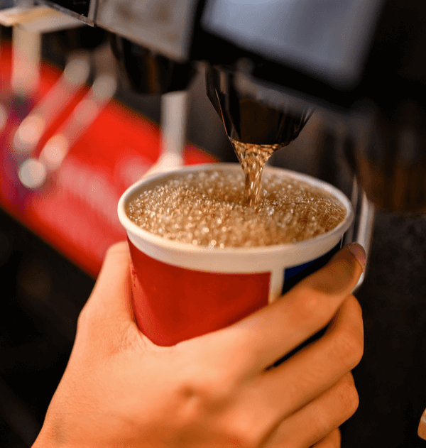 Pouring carbonated soda from restaurant soda machine